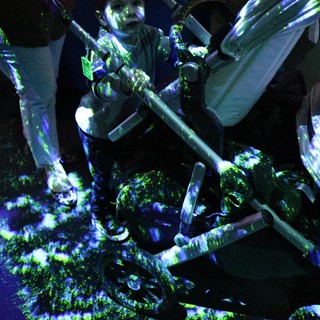 Memorial Vigil with Candles and Flowers Under UV Light