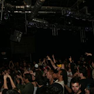 Urban Nightlife: A Concert Crowd with Hands Raised