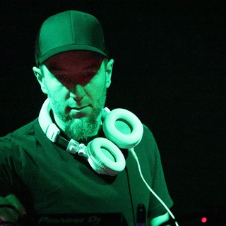 DJ Focused Under Green Stage Lights at Wobbleland