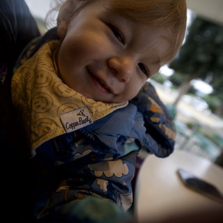 Joyful Toddler Smiling at Family Dinner