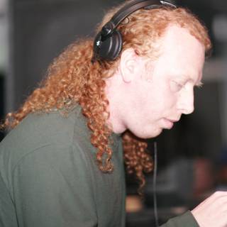 Red-Haired DJ Grooving with Headphones