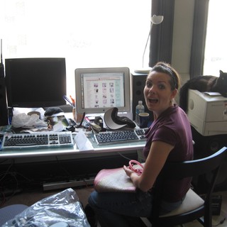 Surprised Woman at Cluttered Dual-Monitor Home Office