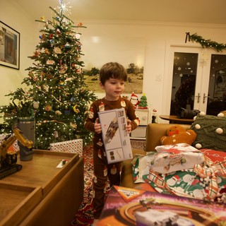 Child Opening Christmas Presents on Christmas Morning