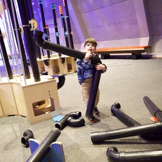 Young Boy Building with Foam Tubes at Interactive Museum