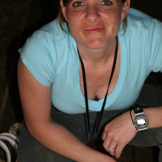 Woman Smiling in Dimly Lit Underground Tunnel