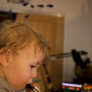 Young Child Playing Harmonica in Home Setting