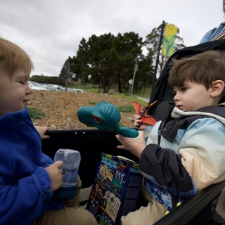 Two Young Boys Share Toys at Outdoor Playground
