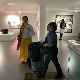 Woman carrying a trash can through an art gallery