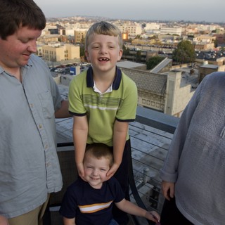 Family Rooftop Gathering at Dusk Over the City
