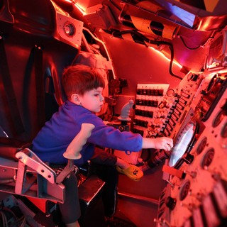 Young Explorer in Submarine Control Room Simulation