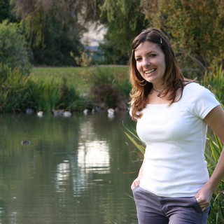 Smiling Woman Posing by Tranquil Park Pond