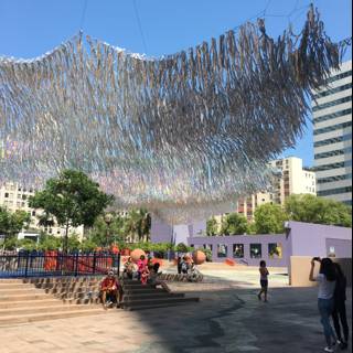 Hanging Paper Sculpture Overlooks Vibrant City Plaza