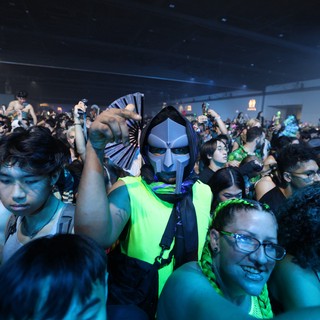 Masked Reveler Points at Camera in Festival Crowd