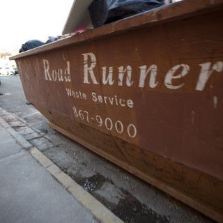 Road Runner Waste Service Dumpster on Urban Street