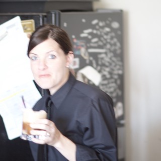 Woman Reviews Bills with Concerned Expression in Kitchen