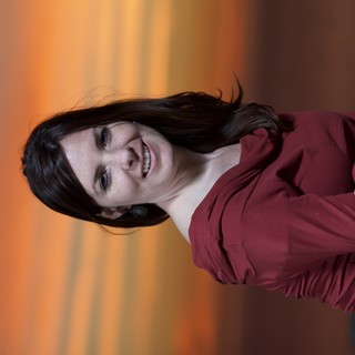 Woman Smiling Against a Vivid Sunset Sky