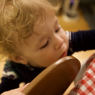 Curious Toddler Examining Wooden Bowl at Christmas