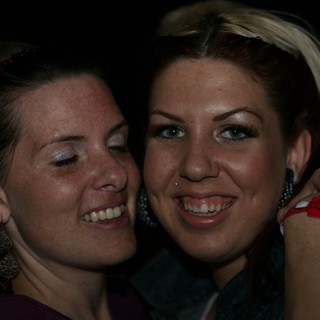 Two Friends Smiling Together at Nighttime Event