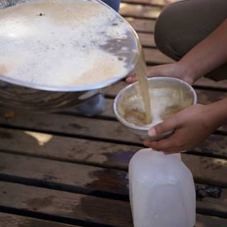Pouring Milk into a Wooden Cup