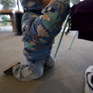 Toddler in Dinosaur Pajamas at Restaurant