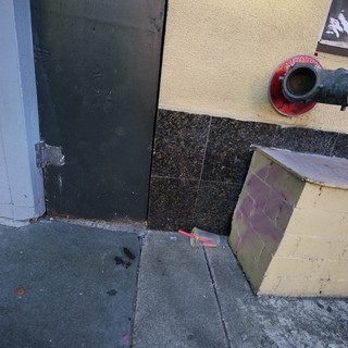 Urban Doorway with Fire Hose and Weathered Architecture