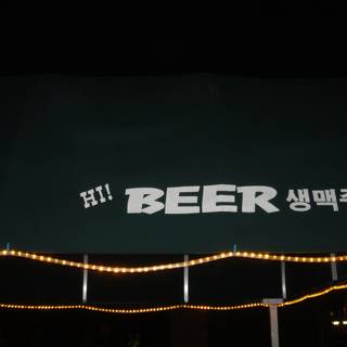 Green Canopy with Beer Sign at Night