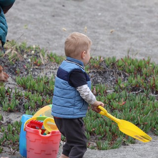 Toddler Ready for Beach Adventure with Yellow Shovel