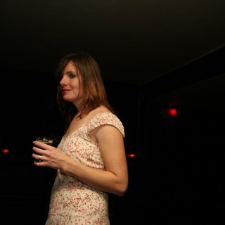 Woman in Floral Dress at Dimly Lit Venue