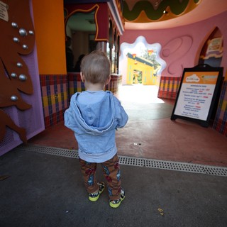 Young Child Explores Colorful Gingerbread House Attraction