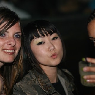 Three Friends Posing Together at a Nightclub Event