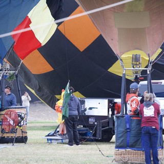 Ground Crew Inflating Colorful Hot Air Balloons at Festival