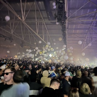 Epic Concert Moment with Floating Balloons and Massive Crowd