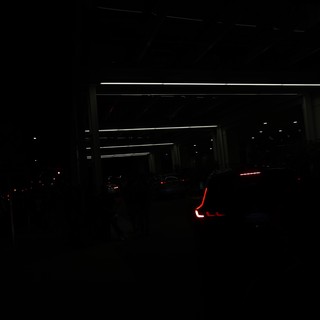 Red Taillights Glow in Dark Parking Structure Night