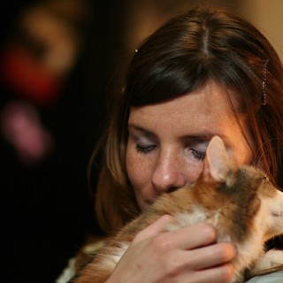 Woman Tenderly Nuzzles Orange Tabby Kitten Close