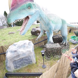 Child Encounters Colorful Spinosaurus Dinosaur at Theme Park