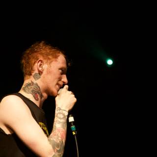 Tattooed man singing passionately with a microphone