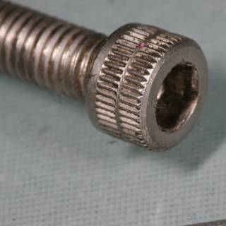 Macro View of a Screw, Nut, and Screwdriver