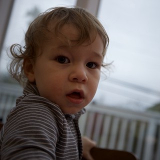 Curious Toddler with Wavy Hair Indoors