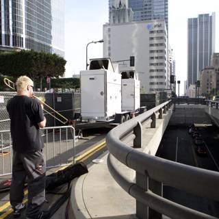 Man on Bridge Observing Truck Below