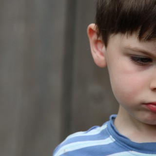 Contemplative Young Boy in Blue Striped Shirt