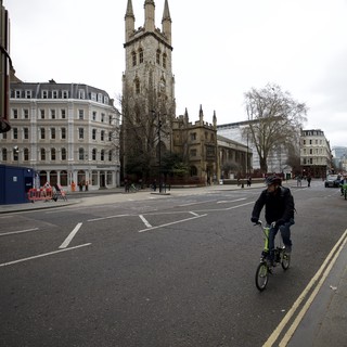 Cyclist Passes Historic Church on Overcast London Morning