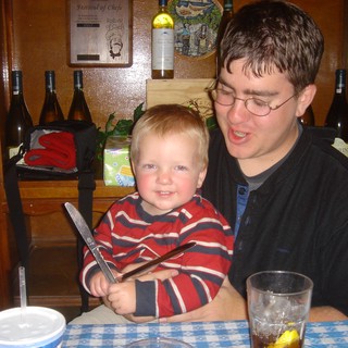 Toddler Grins Mischievously Holding Knife at Restaurant