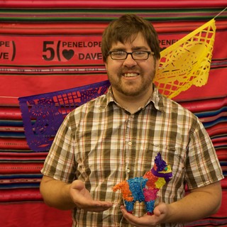 Man Proudly Holds Mini Piñata at Fiesta Anniversary Party