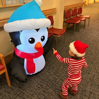 Child Meets Inflatable Snowman in Festive Holiday Setting