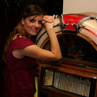 Retro Charm: Woman Poses with Classic Jukebox