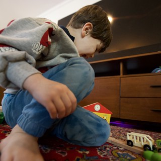 Young Child Playing with Wooden Toys at Home