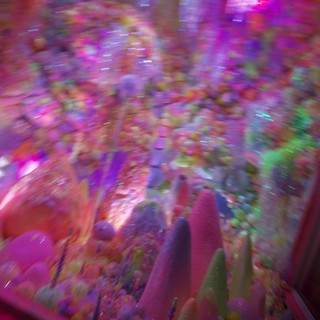 Motion Blur Through Neon-Lit Arcade Claw Machine