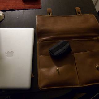 Laptop and Leather Bag on Table