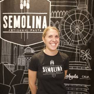 A Happy Woman Stands in Front of a Semolina Sign