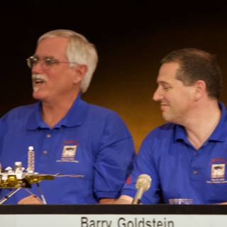 Press Conference with Two Men and Microphone